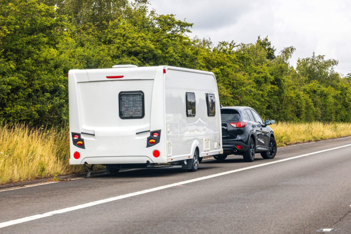 A car towing a camper trailer.