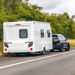 A car towing a camper trailer.