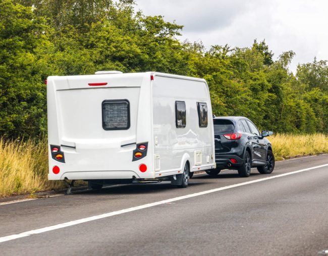 A car towing a camper trailer.
