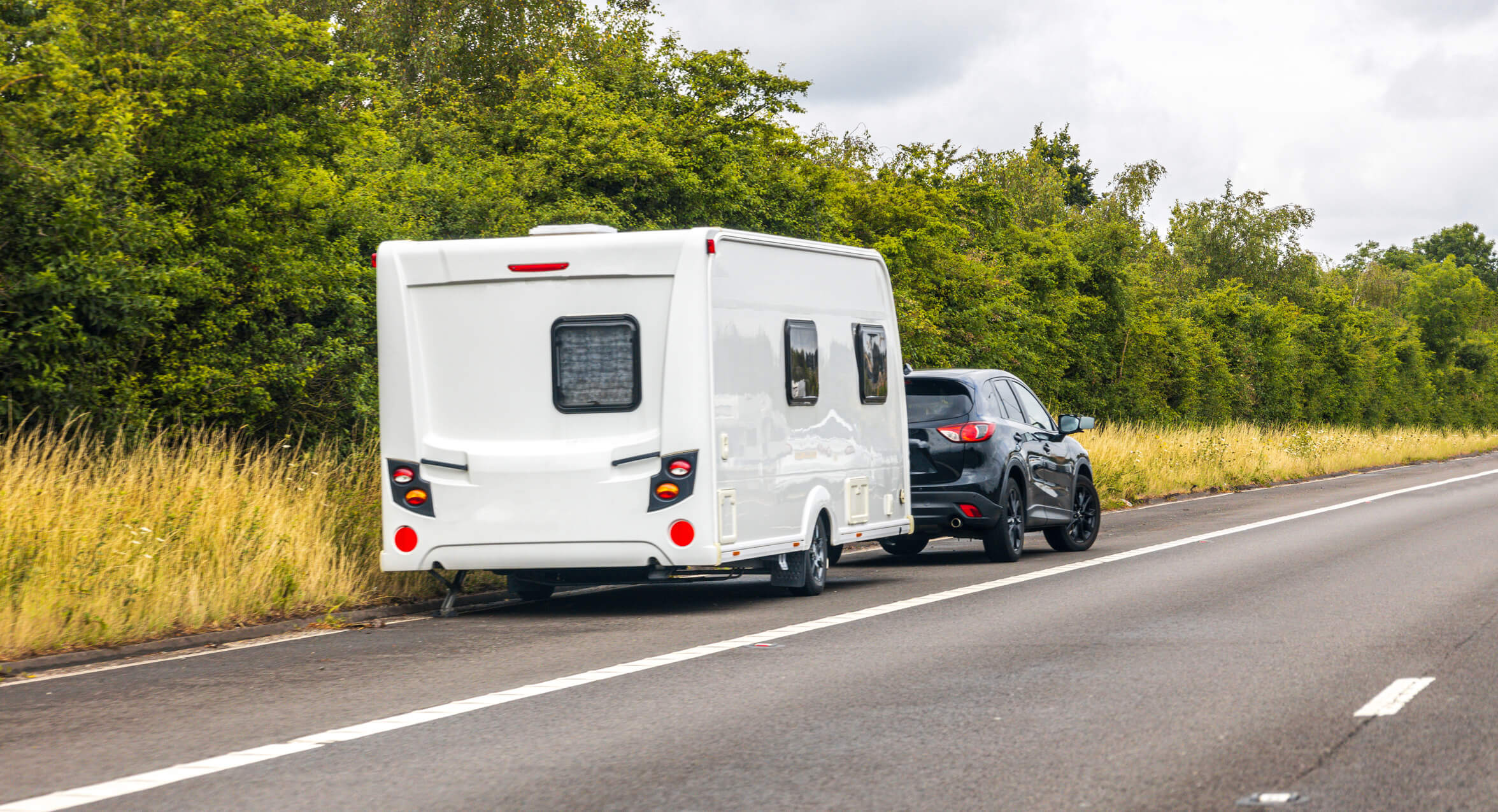 A car towing a camper trailer.