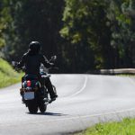Motorcycle rides down the road.