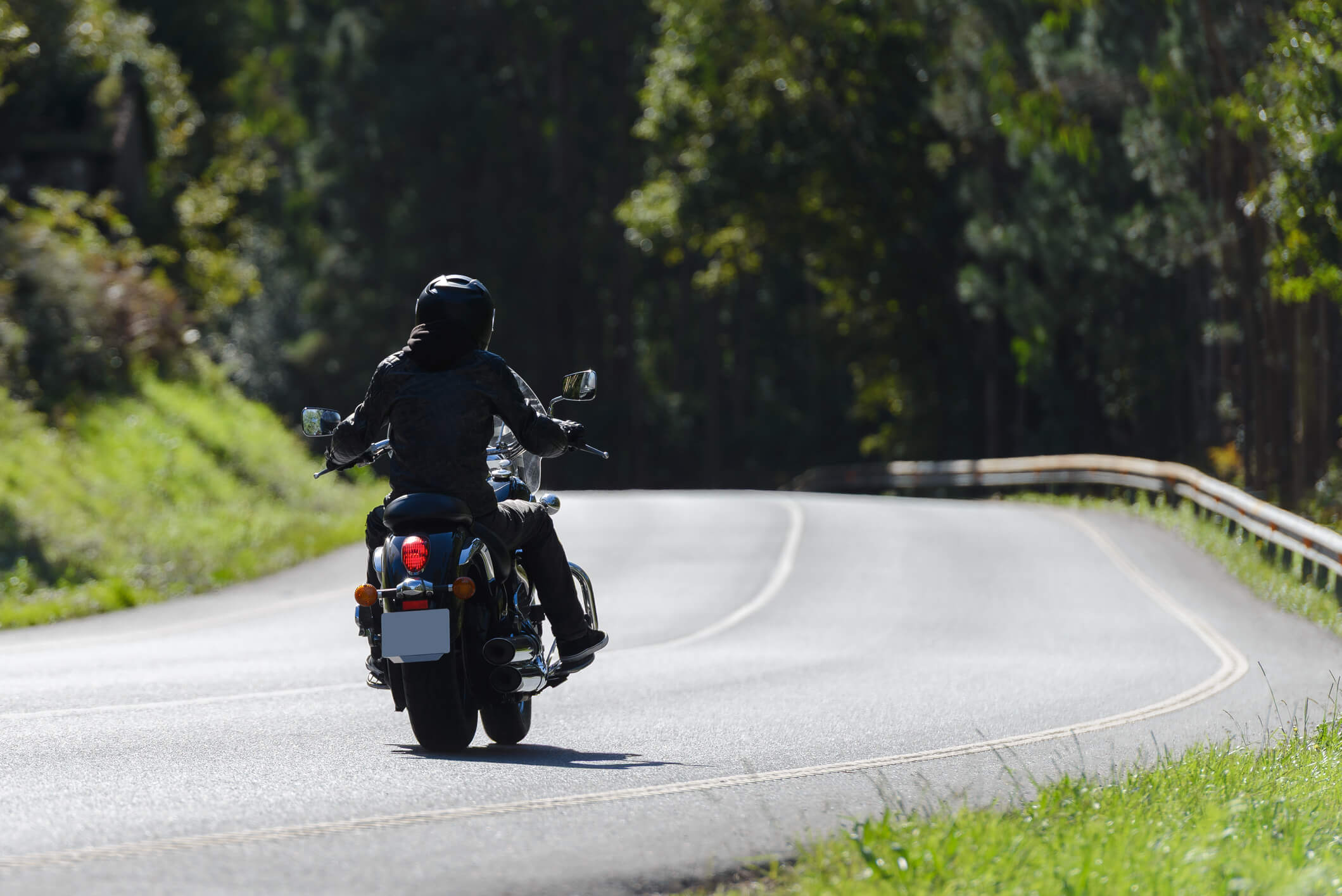 Motorcycle rides down the road.
